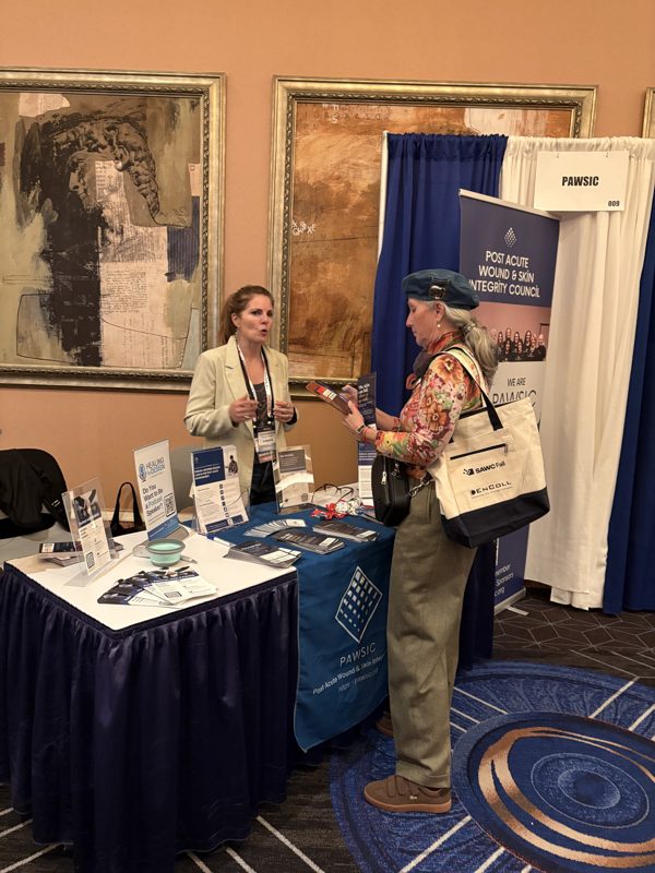 PAWSIC team member speaking with a visitor at the PAWSIC booth at SAWC Fall 2026